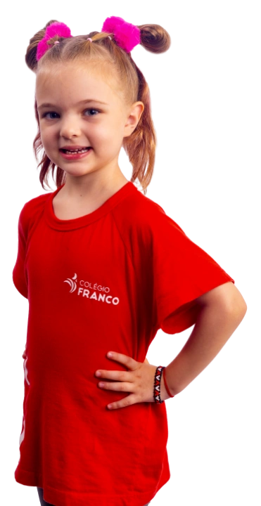 Aluna do Colégio Franco com camiseta vermelha institucional, em pose confiante — destaque para acolhimento na educação infantil e identidade visual da escola trilingue.