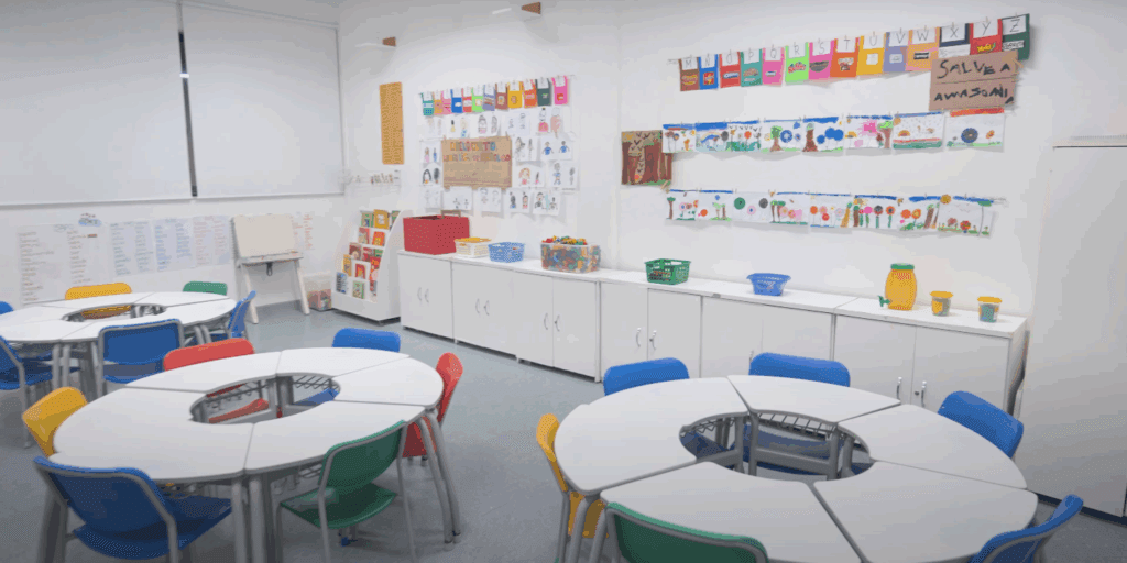 Sala ensino infantil com mesas que em conjunto formam circulos